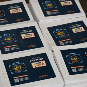 stacks of printed postcards promoting "Your Health Passport" by ArchWell Health, featuring a suitcase graphic with "Health is a Daily Practice" and a QR code for more information.