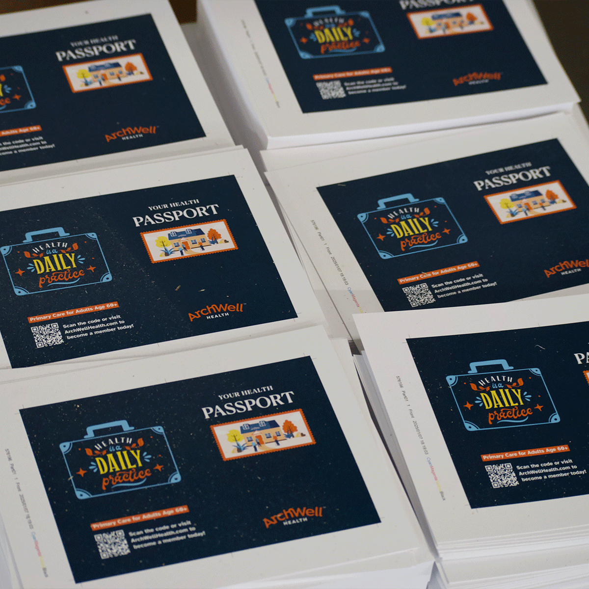 stacks of printed postcards promoting "Your Health Passport" by ArchWell Health, featuring a suitcase graphic with "Health is a Daily Practice" and a QR code for more information.